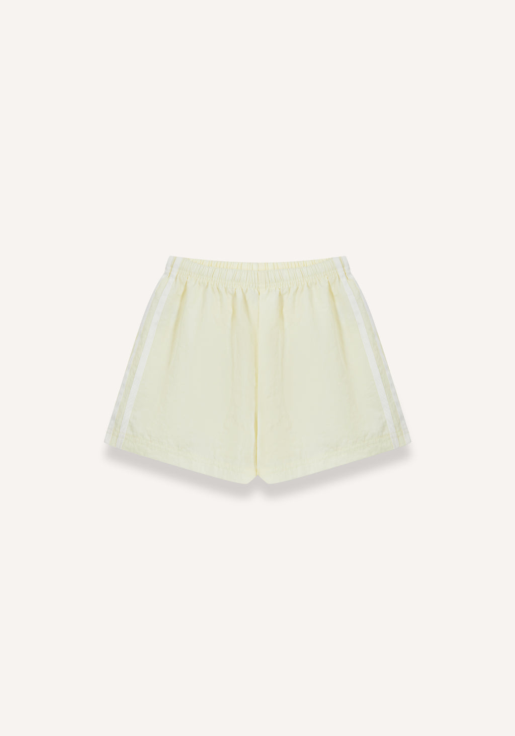 A pair of light yellow athletic shorts with white side stripes, displayed flat against a solid off-white background.