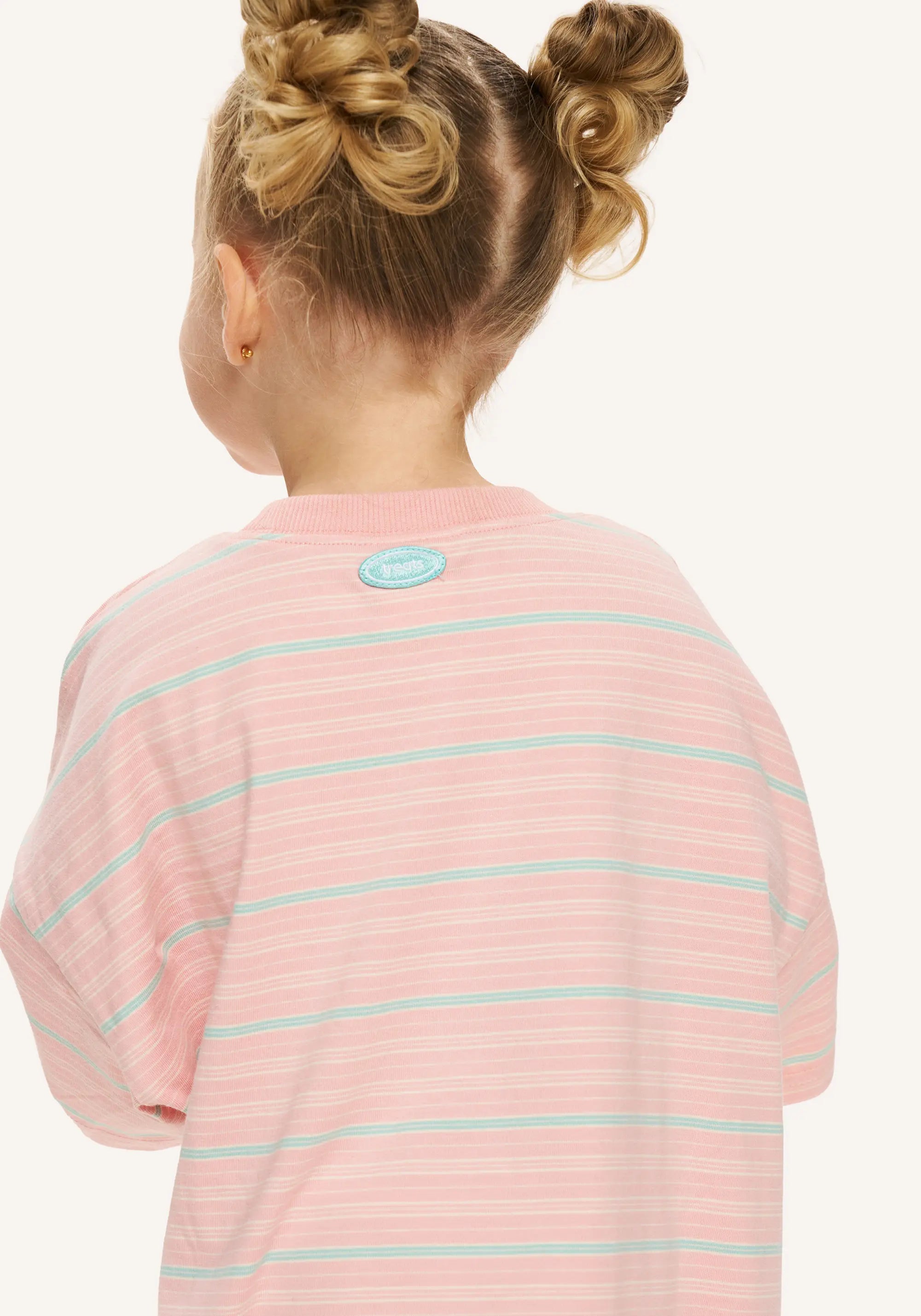 A child shown from the back wearing a pink long-sleeve striped shirt with thin mint green horizontal lines and a small oval logo patch near the neckline, against a plain light background.